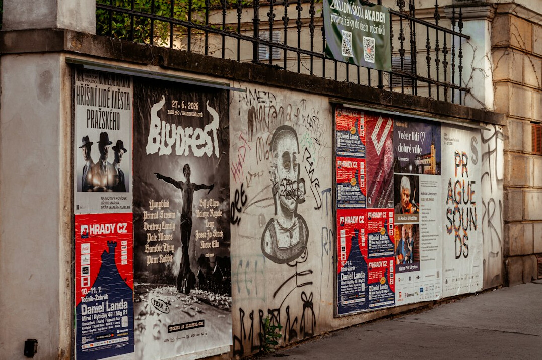 Colorful layered concert posters on a street wall